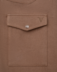 Luxury Western Golf apparel Close-up of a brown textured shirt with a pocket and button on a white background