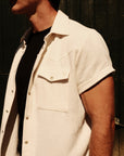 Luxury Western Golf apparel Person wearing a white short-sleeve shirt over a black shirt against a dark background