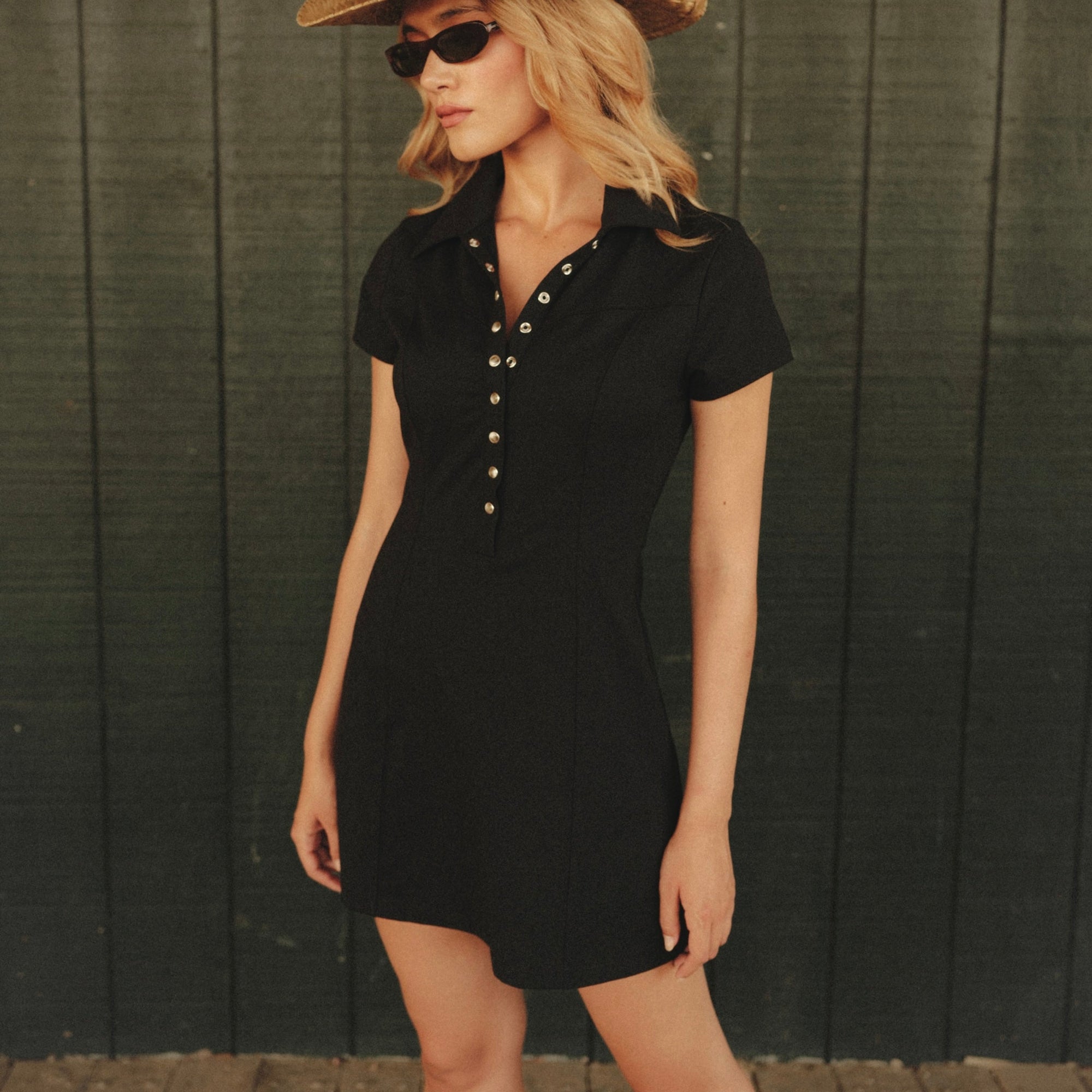 Luxury Western Golf apparel Woman wearing a black dress and straw hat against a wooden background