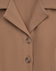 Close-up of a brown jacket with buttons on a matching fabric background