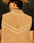 Luxury Western Golf apparel Person wearing a tan quilted vest with a bull emblem and a cowboy hat against a dark background